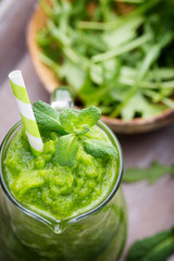 Rucola smoothie, on the grey  background.