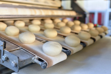 Fliessband mit Brötchen in einer Fabrik - automatisierte Produktion in einer Großbäckerei //...