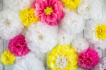 Paper handmade flowers isolated on white wood background. Beautiful floral background of white, pink and yellow colors.
