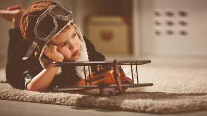 concept of dreams and travels.  pilot aviator child with a toy a - obrazy, fototapety, plakaty