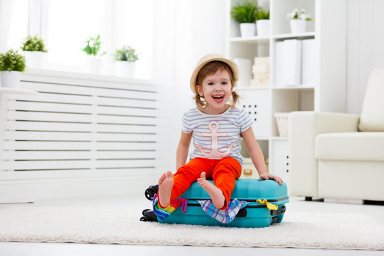 Happy Child Girl Packs Clothes Into Suitcase For Travel, Vacatio