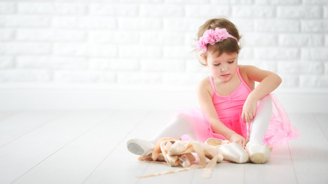 little child girl dreams of becoming  ballerina with ballet shoe