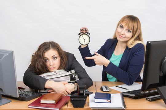 The girl in the office with a smile, indicating the hours and tortured colleague