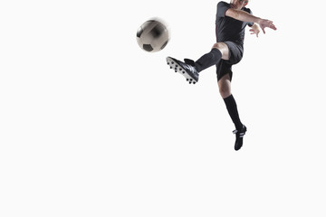 Athlete kicking soccer ball - Powered by Adobe