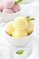 Lemon and strawberry ice cream cups with mint leafs.