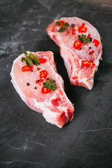 fresh uncooked pork meat on bone on grange black background