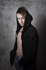 Teen boy tattooed with hoodie looking aggressive