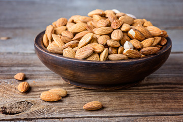 Almonds on a wooden bowl. Selective focus.  Protein diet. Healthy food concept.
