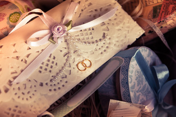 Vintage wedding invitation envelope with ribbon among git boxes