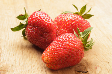 Red fresh strawberry fruits on wooden table.