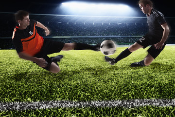 Obraz na płótnie Canvas Two soccer players kicking a soccer ball