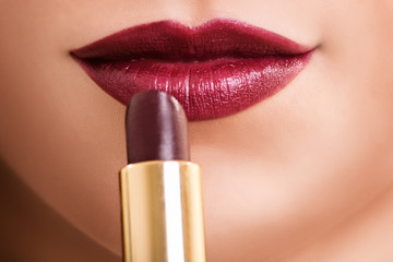 Close up shot of a female mouth putting lipstick