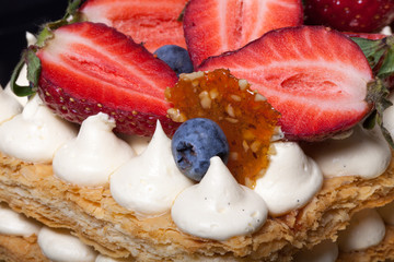 Puff homemade cake with cream and berries. Selective Focus. Shal