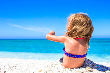Adorable little girl have fun at tropical beach during vacation