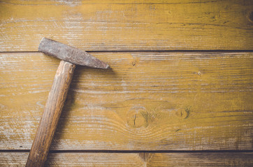 Old rusty hammer on wooden table