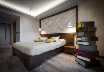 Double bed in brown colored bedroom interior