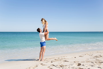 Obraz na płótnie Canvas Happy couple jumping on beach vacations