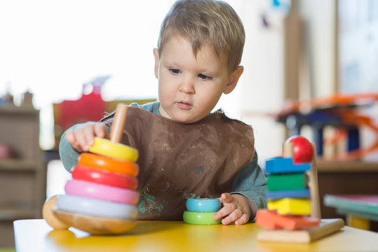 Caucasian boy playing with toys in preschool