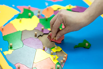 Child playing with wooden block map