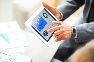 businessman hands on a digital tablet with finansowym schedule