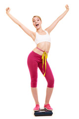 Woman measuring on weighing scale with raised arms