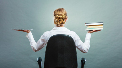 Woman holding traditional book and e-book reader