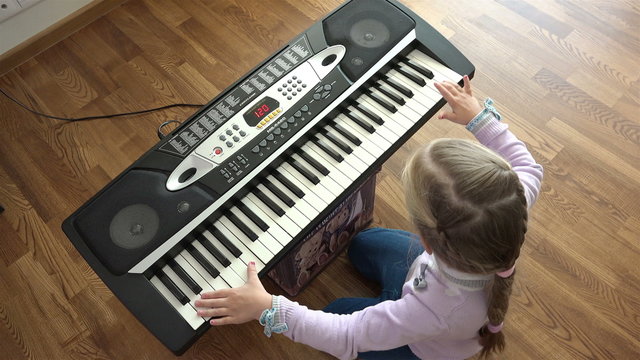 Hands of kid on piano keyboard  top view.