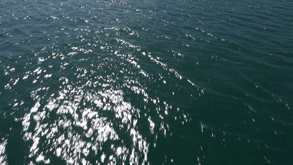 Fly over water, sun shines on water