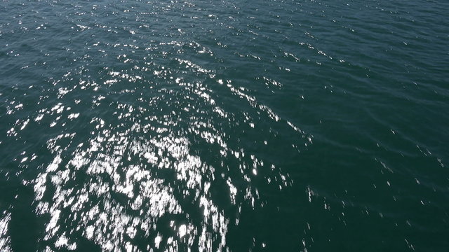 Fly over water, sun shines on water