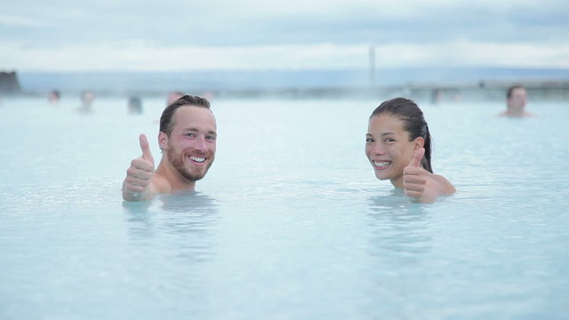 Hot spring geothermal spa on Iceland. Romantic couple in love relaxing in hot pool on Iceland. Young woman and man enjoying bathing relaxed in a blue water lagoon Icelandic tourist attraction. Sunset.