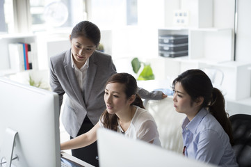 Three business women looking at the desktop