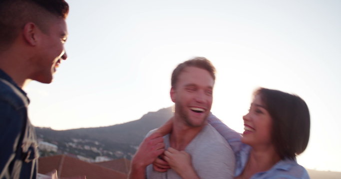 Teenage friends on summer rooftop party at sunset