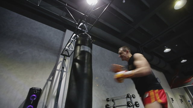 Sports: Man is practicing kick in a boxing gym