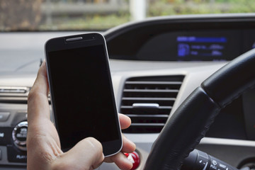 Man holding a smartphone in the car.