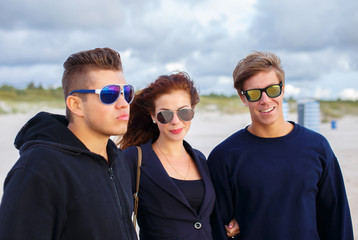 Two attractive guys and a woman in sunglasses.