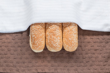 three  soft bread with sesame seed  on brown clothes