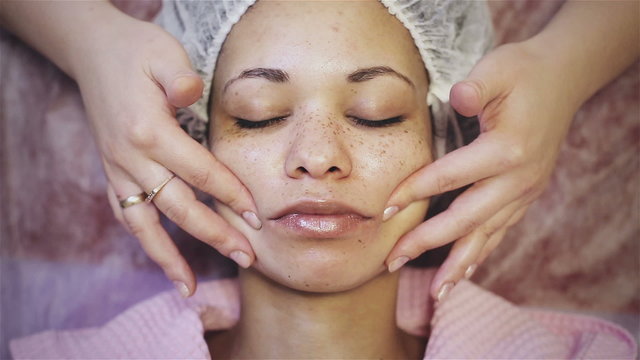 African american woman getting facial massage at spa salon