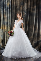 Attractive bride in wedding dress in studio