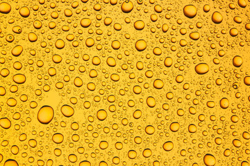Water drops on orange glass surface texture.