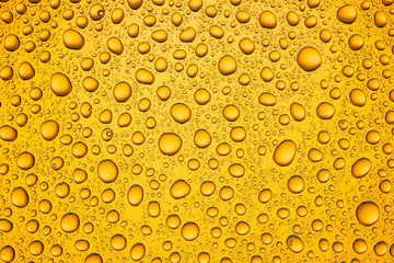 Water drops on orange glass surface texture.