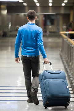 Traveler walking with suitcase at airport