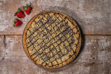 cake on a rustic surface with strawberries on the side