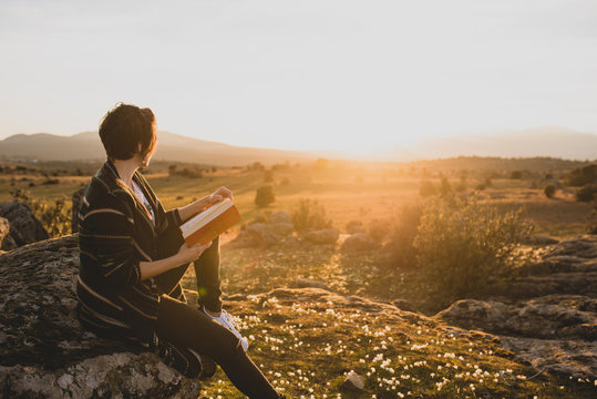 Woman resting on a rock watching nature