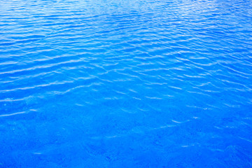 Blue pool water with sun reflections