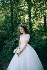 Obraz na płótnie Canvas Beautiful sensual bride with rustic wedding hairstyle in the forest. Outdoor portrait of young gorgeous bride. Wedding.