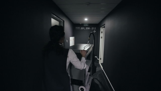 Hotel: Maid with housekeeping cart in a corridor at hotel