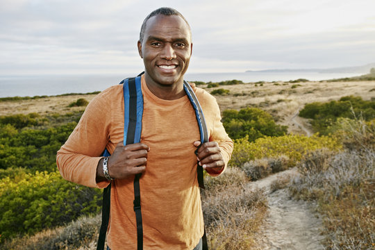 Black man hiking on rural path