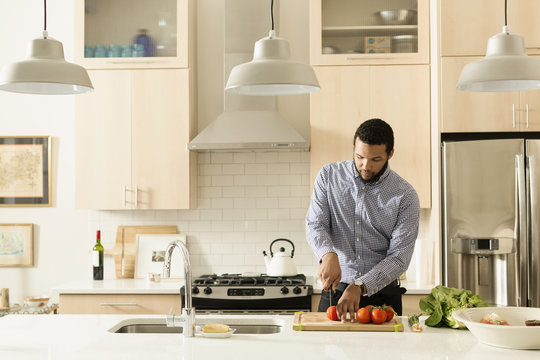 Mixed race man cooking in kitchen