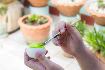 Painting easter eggs on hand.