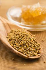 Fresh bee pollen in the spoon with honeycomb